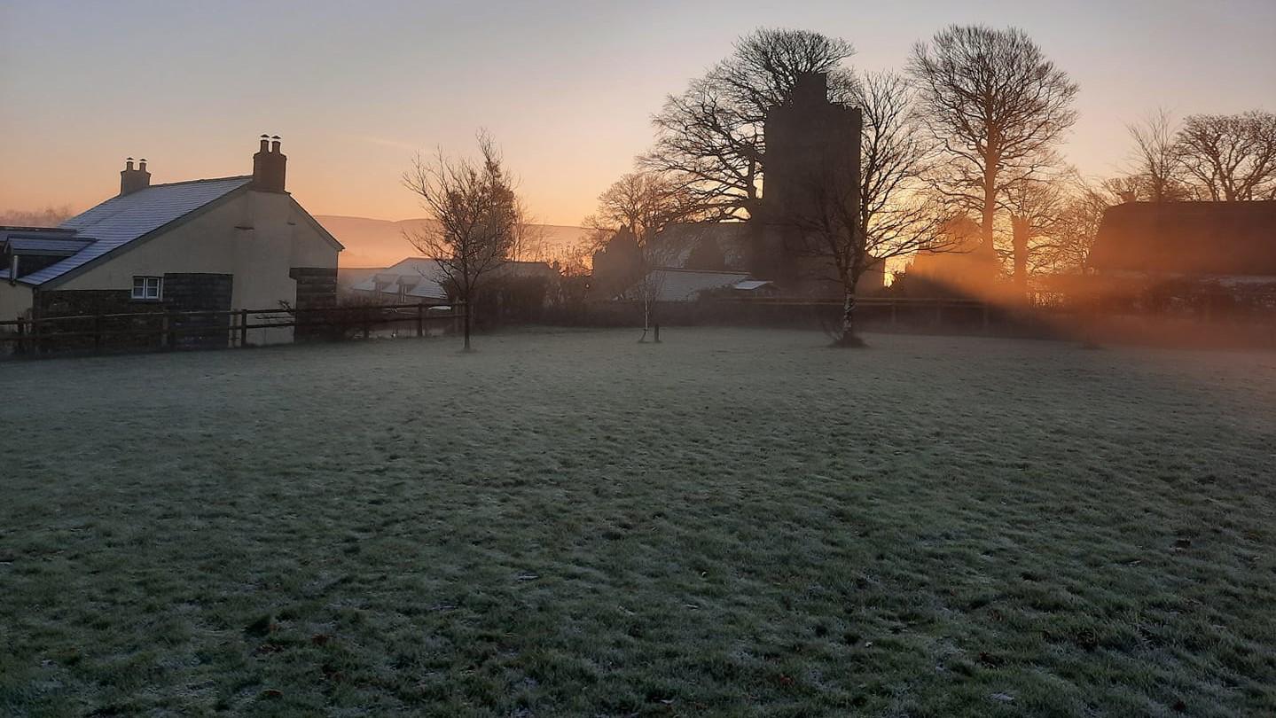 the playing field overlooking the church and a house, very early on a frosty morning